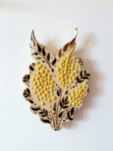 Keraaminen kuva lehtikoristeella ja keltaisilla pisteillä