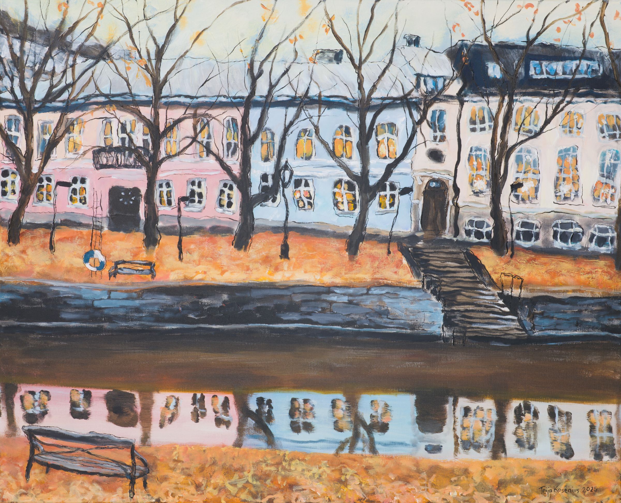 Syksyinen jokimaisema pastellitalojen edustalla