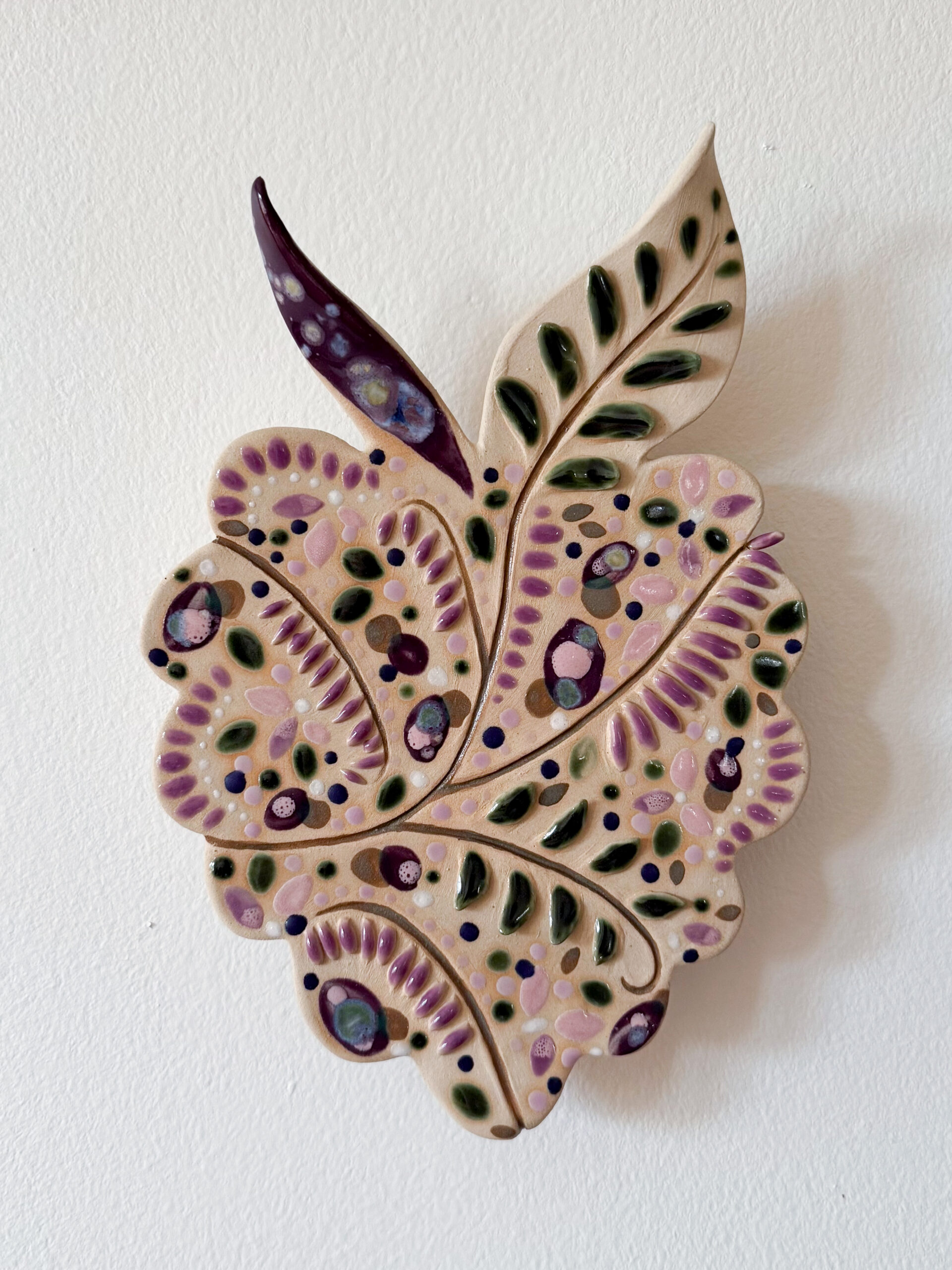 Koristeellinen keramiikkalehti vaalealla taustalla