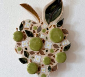 Keramiikkalehti vihreillä ja valkoisilla kiinnostavilla yksityiskohdilla.