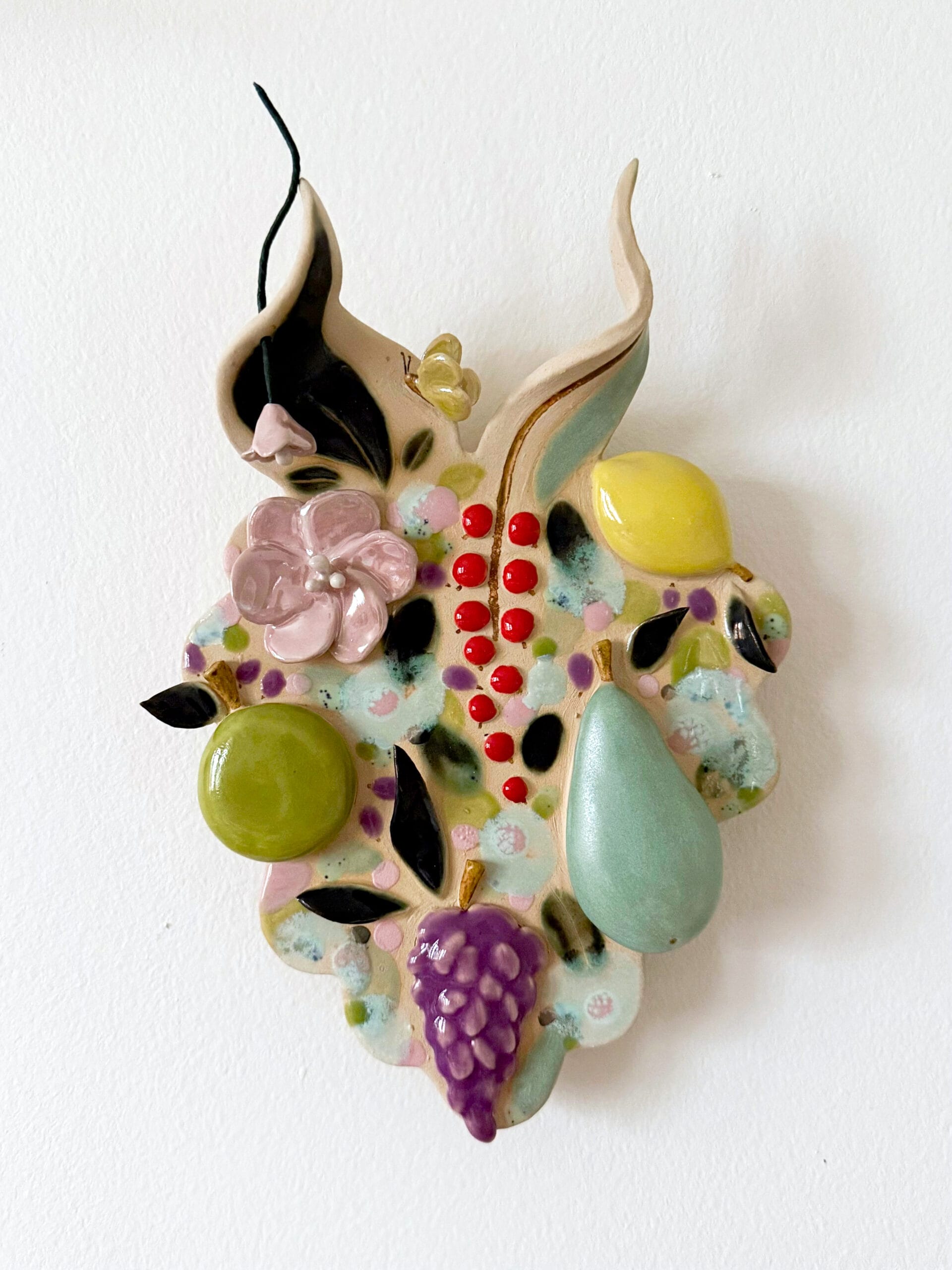 Värikäs keraaminen hedelmätäkkuno koriste seinällä.