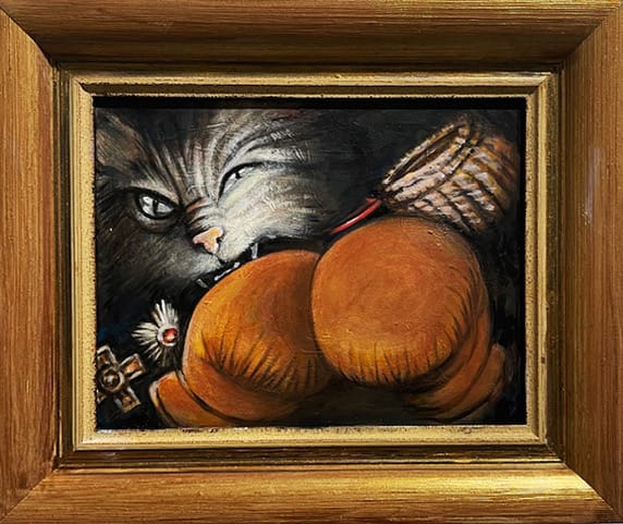 Kissa pureskelee isoa oranssia tyynyä.