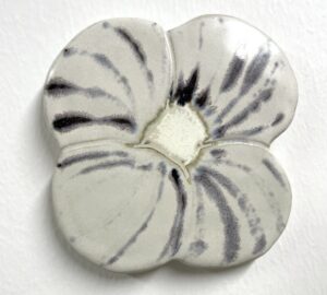 Keraaminen valkoinen kukka koriste seinällä.