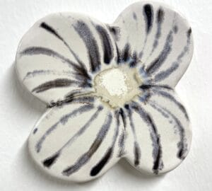 Valkoinen keramiikkakukka mustilla raidoilla