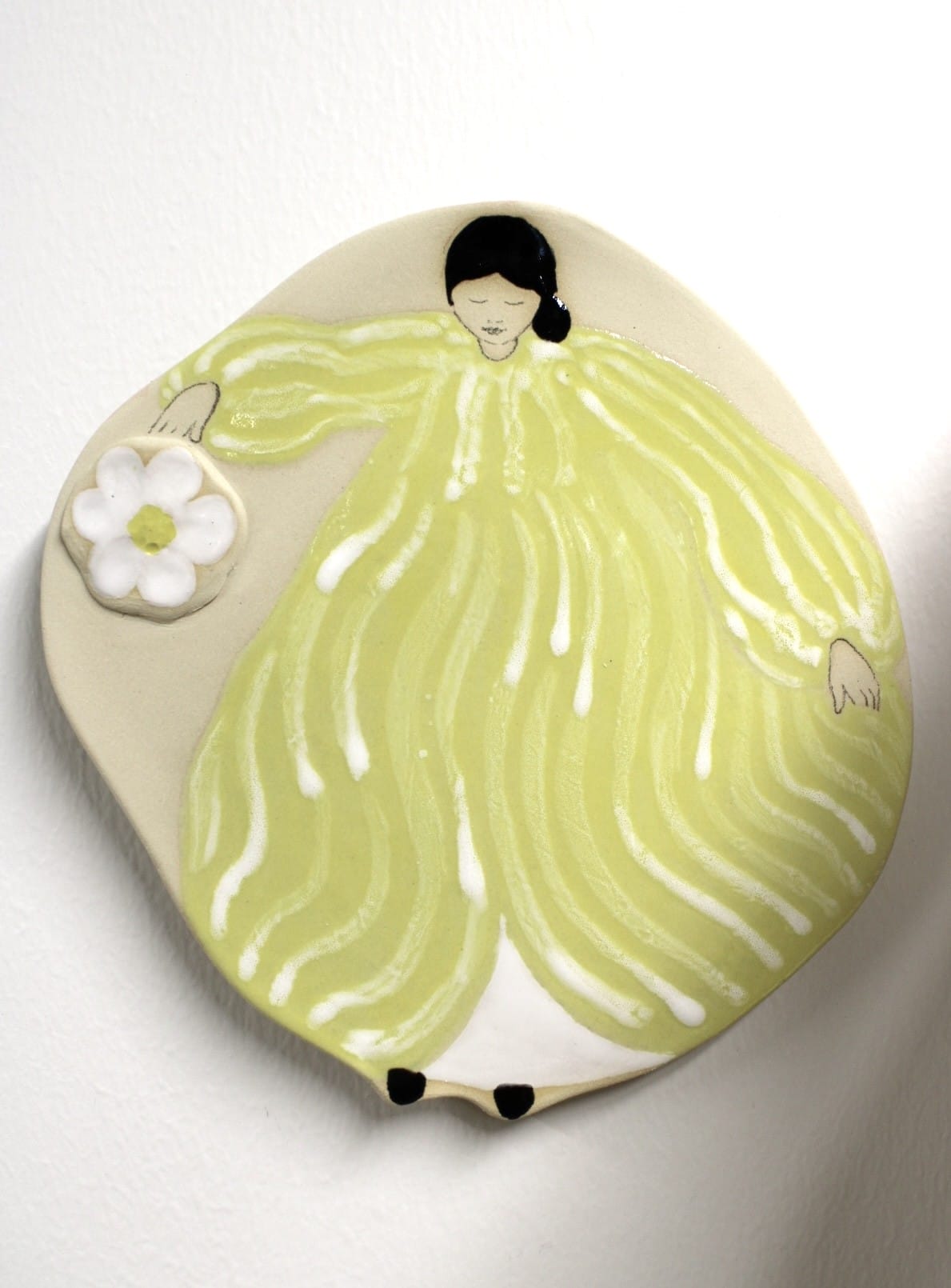 Valkoinen kukka ja hahmo keltaisessa mekossa