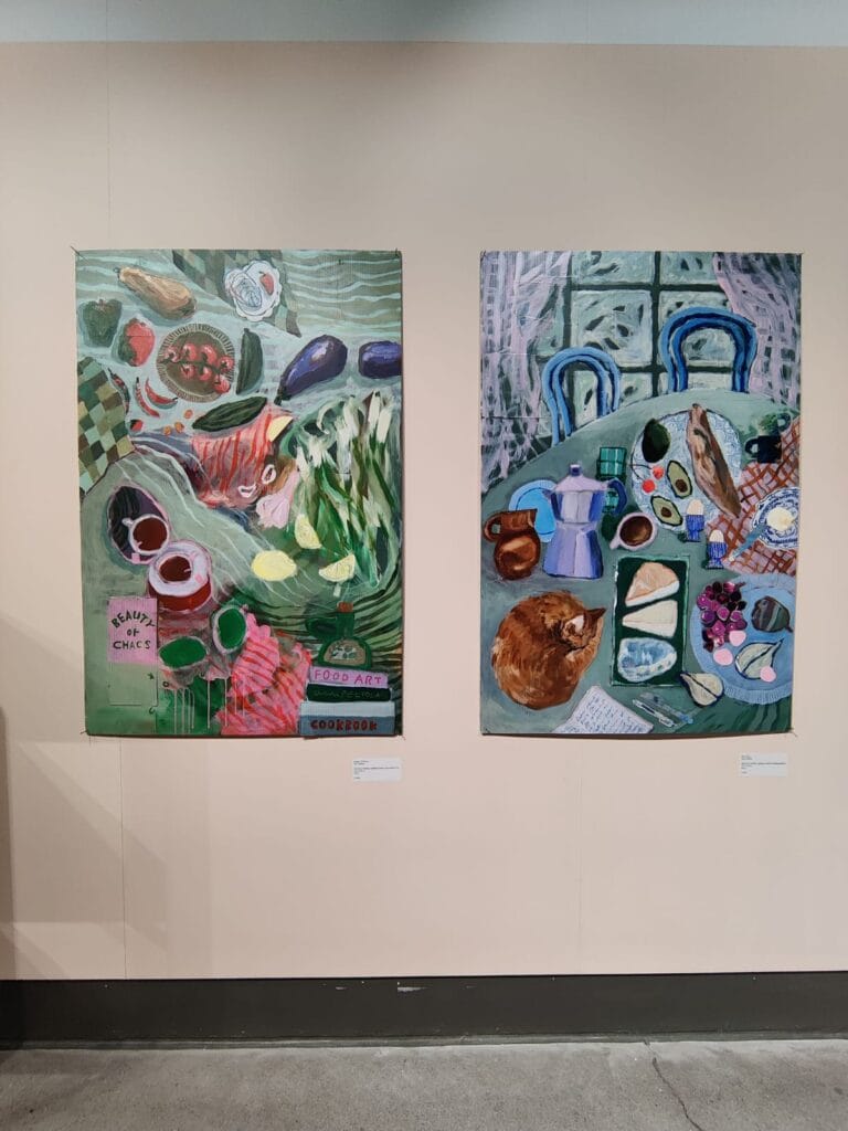 Kaksi värikästä maalausta ruoka-aiheilla seinällä