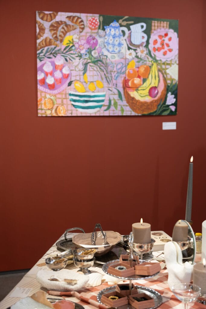 Värikäs asetelma hedelmistä ja esineistä pöydällä.