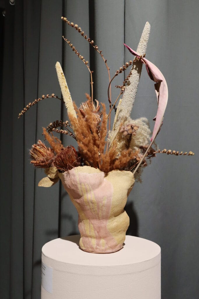 Kuivakukkakimppu vaaleanpunaisessa keramiikkamaljakossa