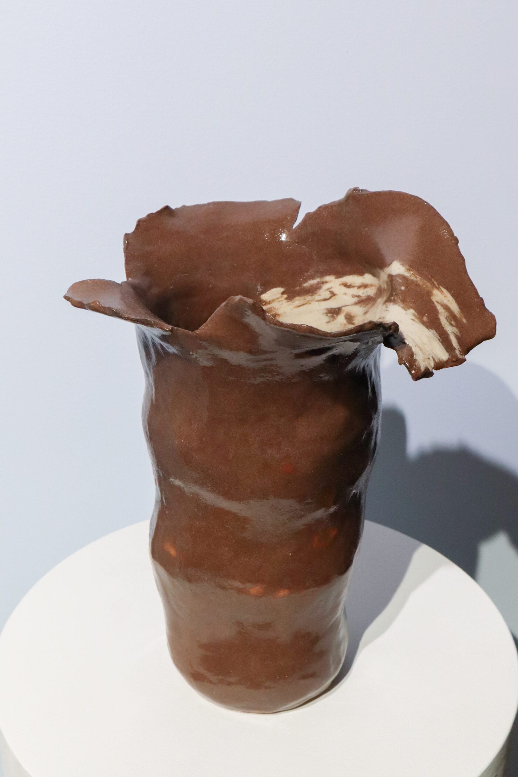 Ruskea keramiikkamaljakko valkoisella alustalla