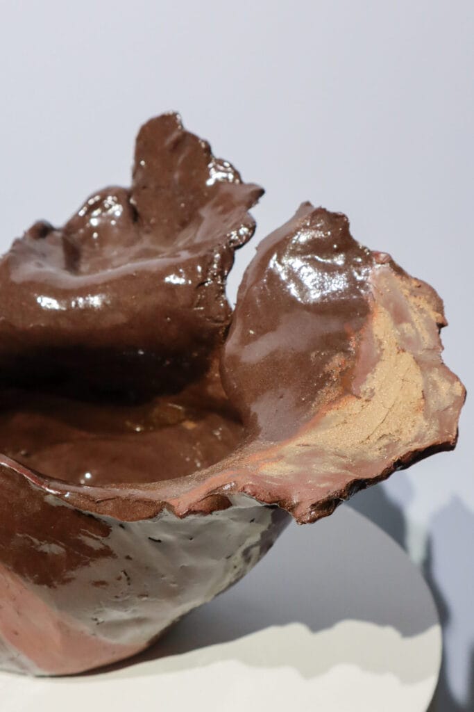 Ruskea keraaminen veistos kiiltävällä pinnalla