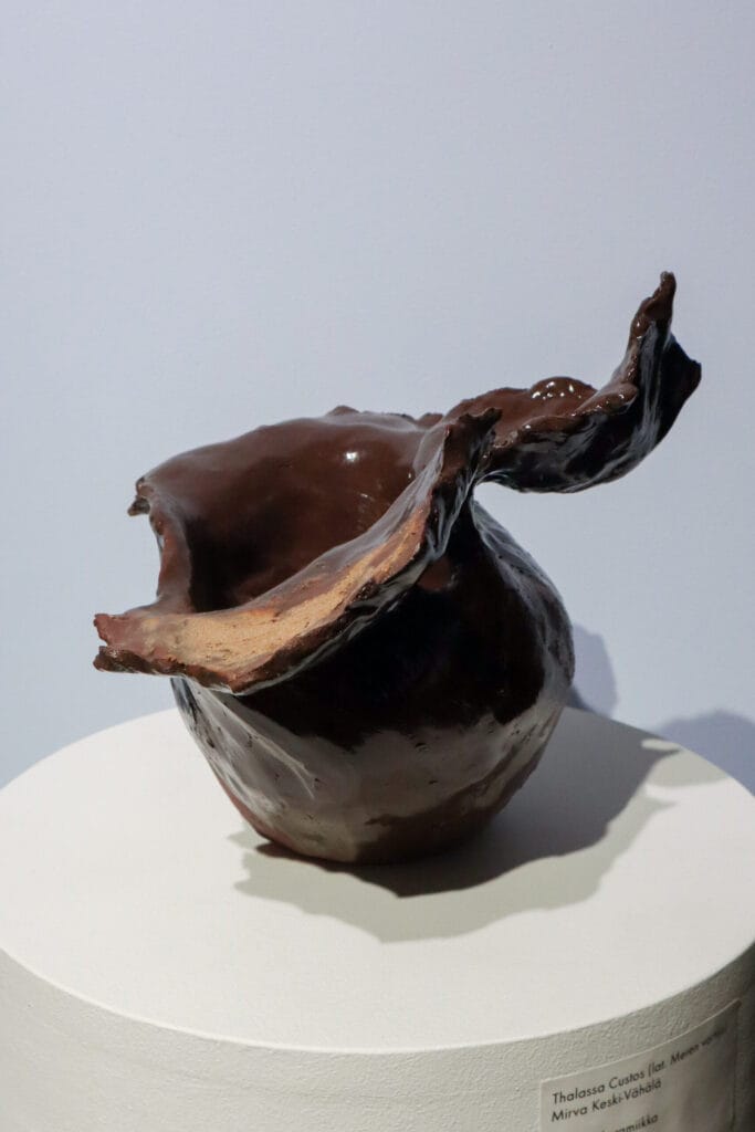 Ruskea keraaminen taideteos jalustalla