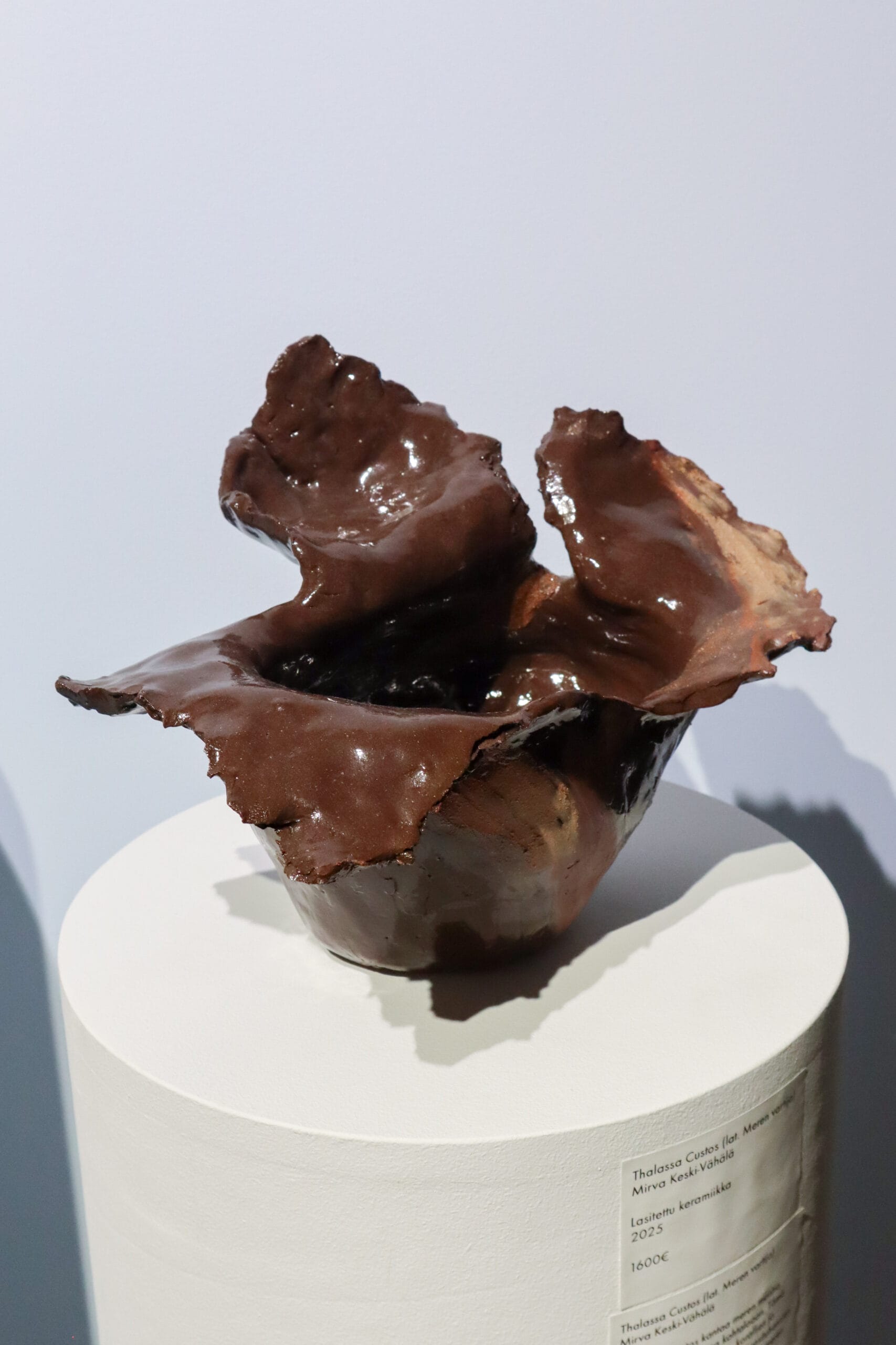 Lasitettu ruskea keraaminen veistos näyttelyssä.