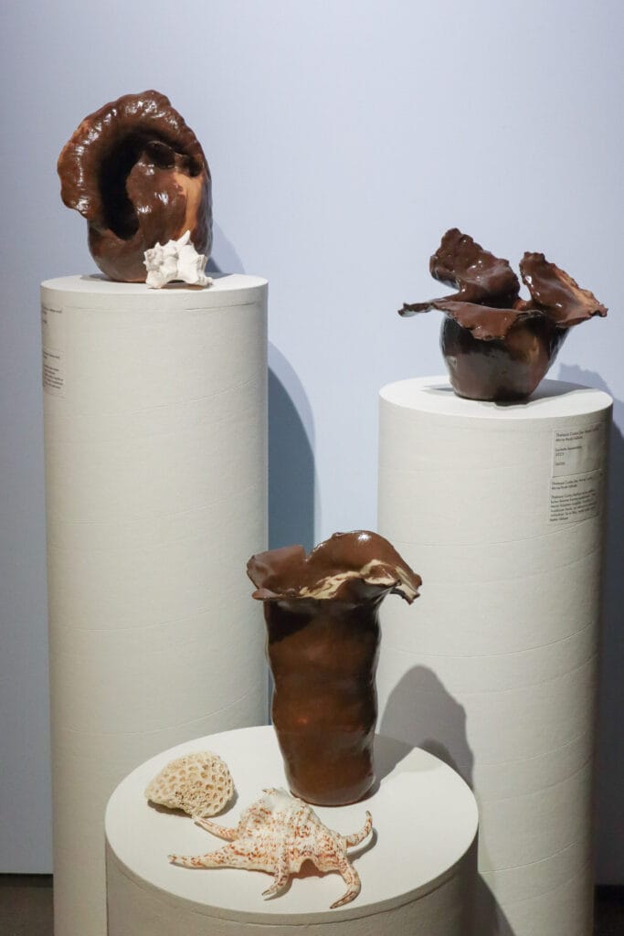 Keraamiset veistokset esillä jalustoilla näyttelyssä.