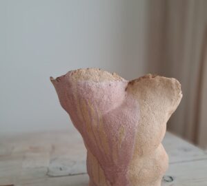 Abstrakti keramiikkaveistos puisella pöydällä