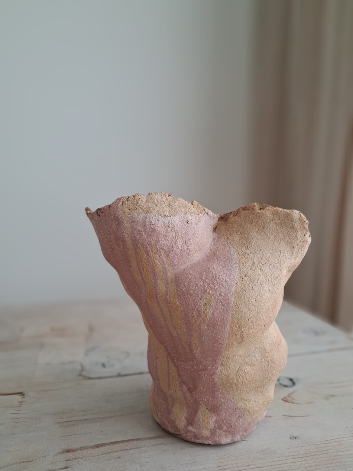Abstrakti keramiikkaveistos puisella pöydällä
