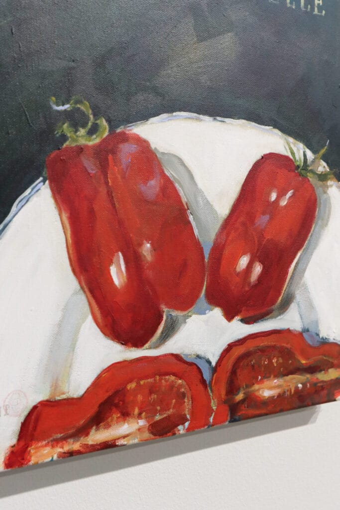 Maalattu paprika valkoisella lautasella tummalla taustalla.