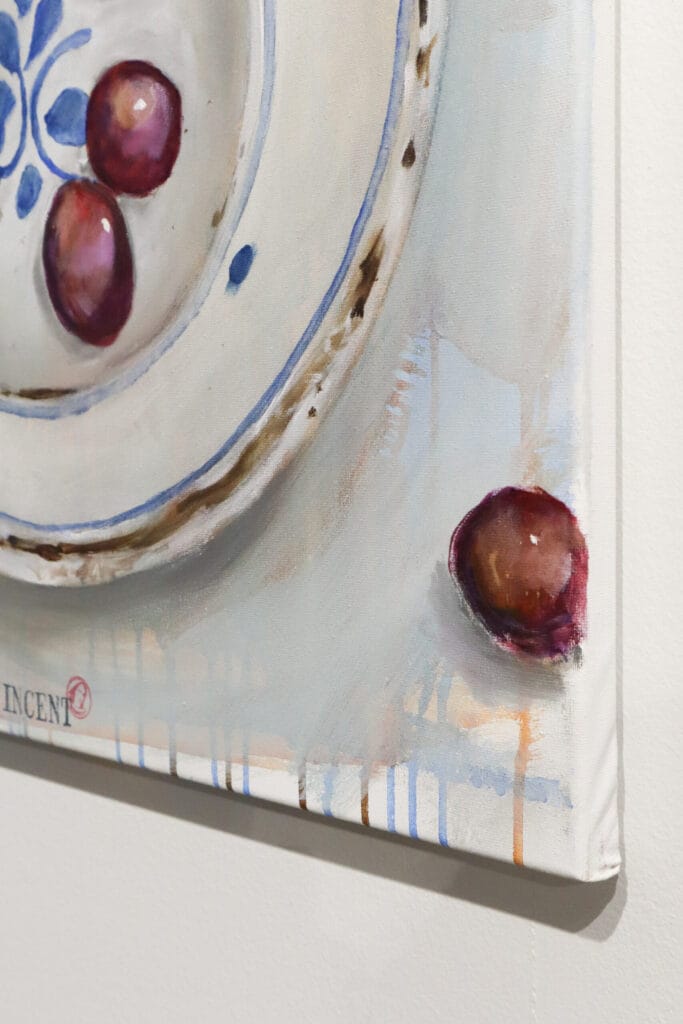 Taulussa lautanen ja rypäleitä maalattuna.