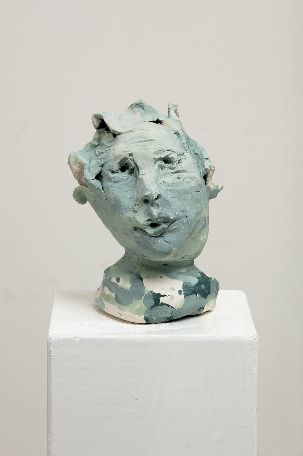 Veistos keraamisesta päästä, vaaleansininen sävy.