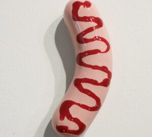 Posliinimakkara ketsuppipäällisellä seinällä.