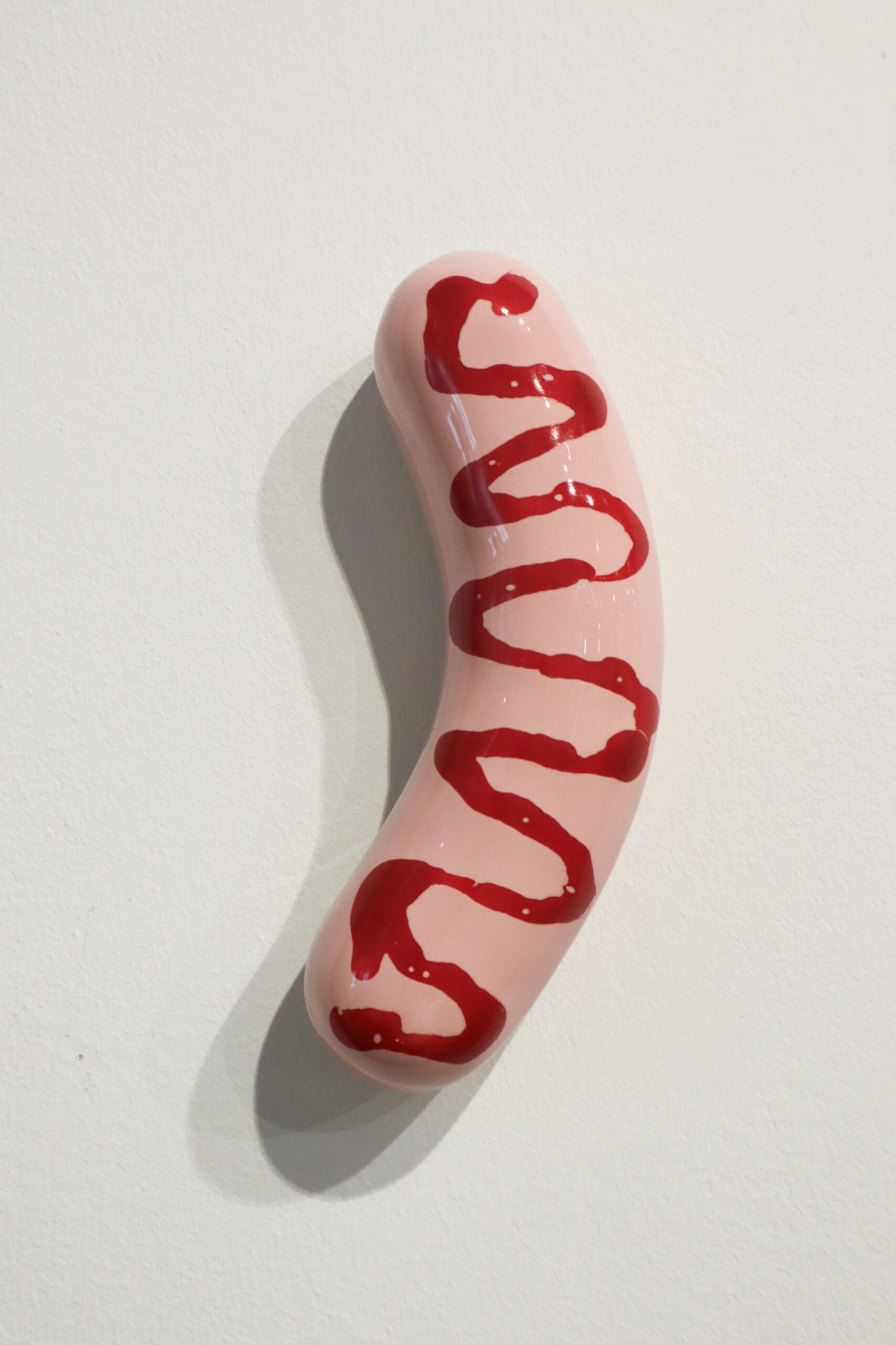 Posliinimakkara ketsuppipäällisellä seinällä.