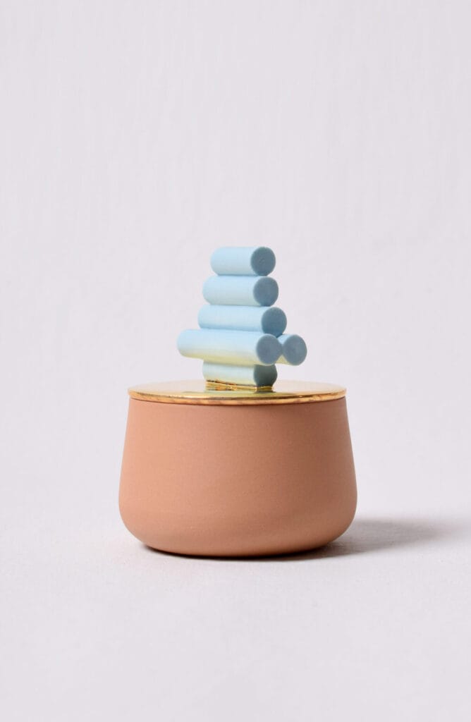 Noin kuusi eriväristä pyöreää tikkua purkissa.