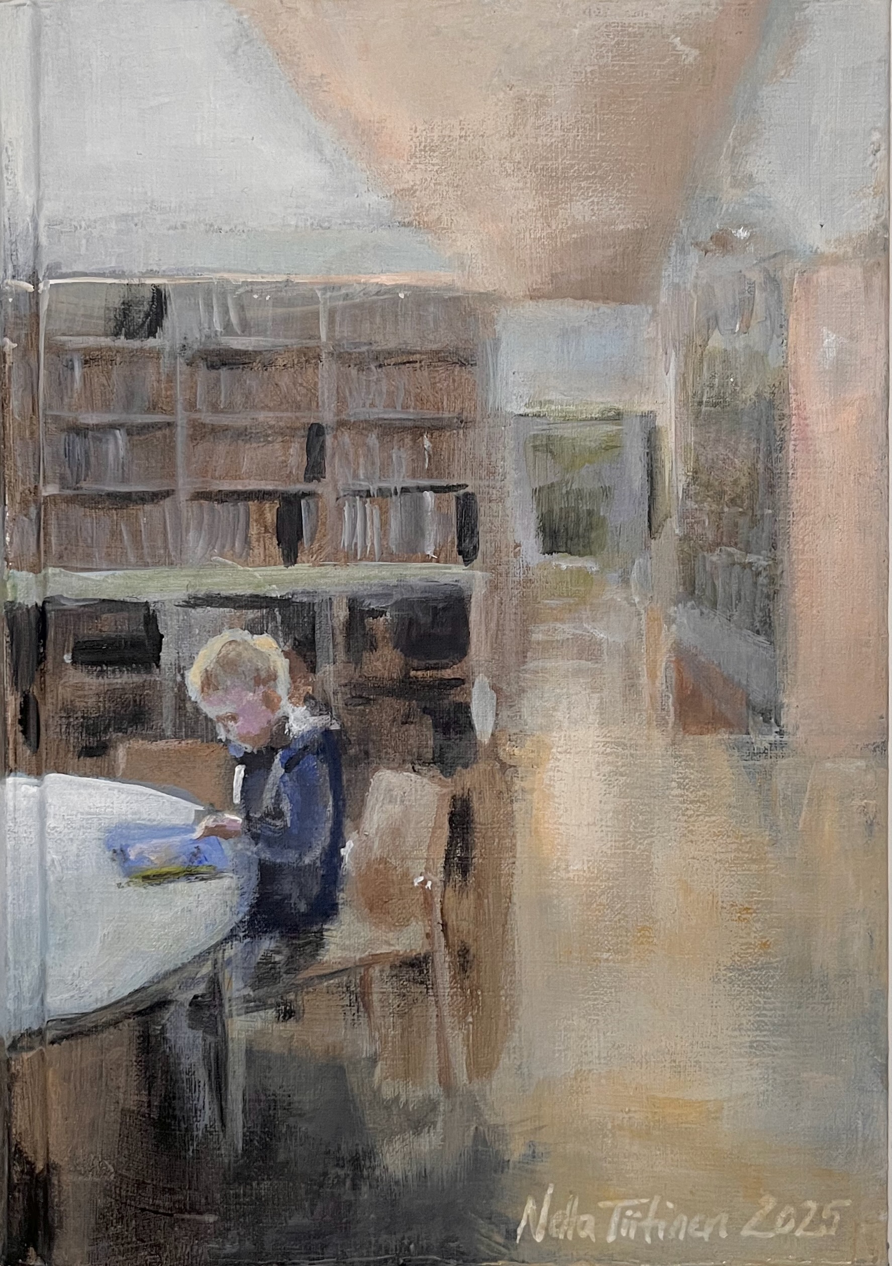 Lapsi lukee kirjaa kirjastossa pöydän ääressä.