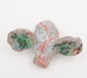 Värikäs keraaminen veistos valkoisella taustalla