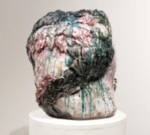 Monivärinen keramiikkaveistos jalustalla