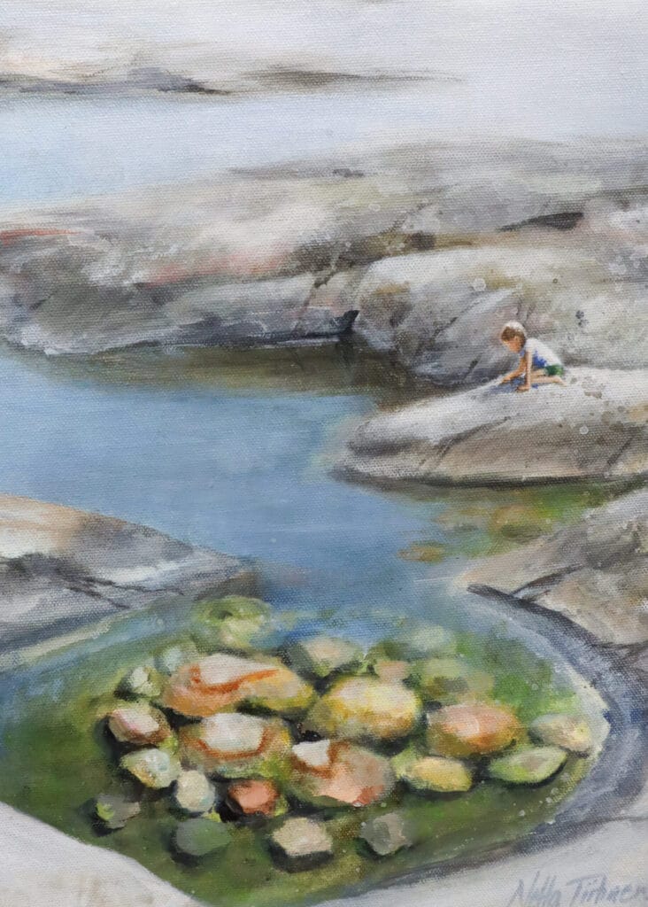 Lapsi leikkii kivisellä rannalla.