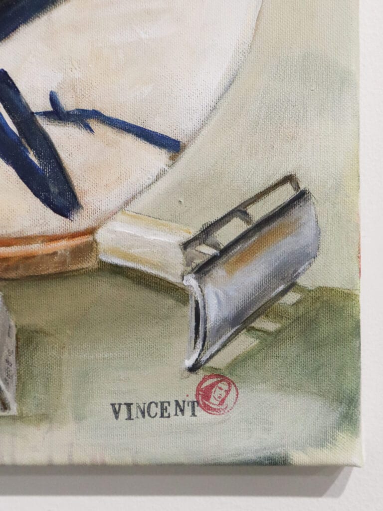 Vincent-signatuuri maalauksessa, partakoneen terä taustalla.
